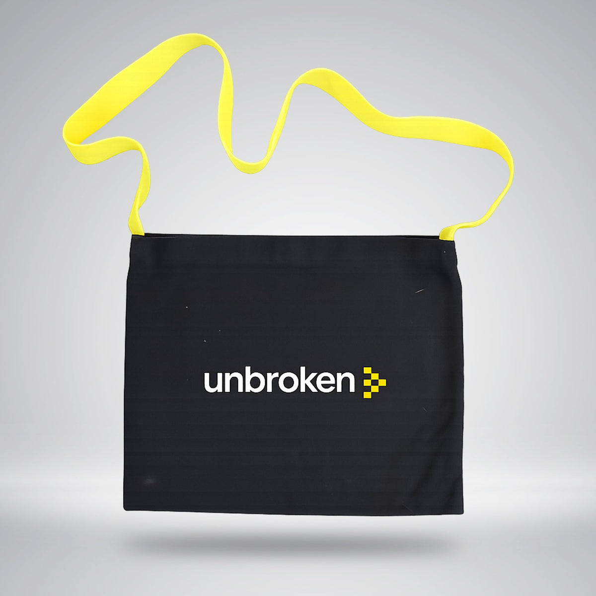 Black Unbroken musette bag with a yellow shoulder strap